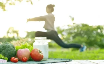 A woman exercises outdoors with fresh vegetables and a jar of milk on a table, highlighting a healthy lifestyle.