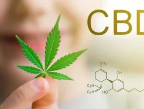 Close-up of a person holding a cannabis leaf with "CBD" text and chemical structure illustration in the background.