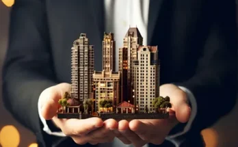 A person in a suit holds a miniature cityscape with skyscrapers and trees, symbolizing real estate or urban development.