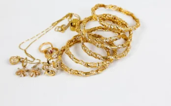 A collection of elegant gold jewelry including rings, bangles, and necklaces, adorned with intricate designs and sparkling stones.