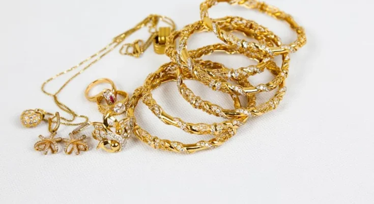 A collection of elegant gold jewelry including rings, bangles, and necklaces, adorned with intricate designs and sparkling stones.