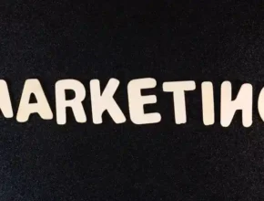 The word "MARKETING" displayed in playful, white letters on a black background.
