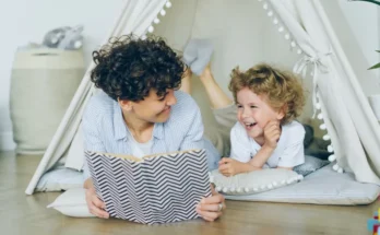 A cozy scene of a parent reading a book inside a tent-like structure to a child, surrounded by soft cushions and playful decor.
