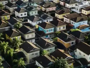 Aerial view of a dense urban neighborhood featuring colorful houses and lush greenery, showcasing a variety of architectural styles.