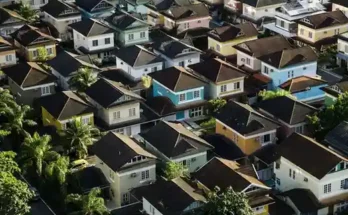 Aerial view of a dense urban neighborhood featuring colorful houses and lush greenery, showcasing a variety of architectural styles.