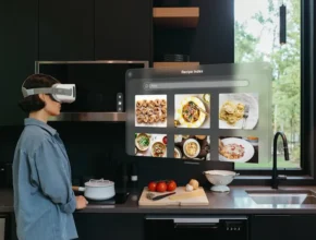 A person wearing a VR headset stands in a modern kitchen, viewing digital recipe images on a virtual screen while preparing food.