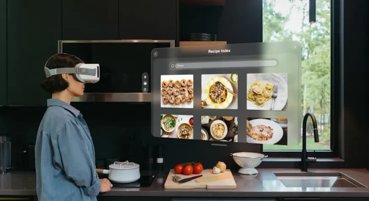 A person wearing a VR headset stands in a modern kitchen, viewing digital recipe images on a virtual screen while preparing food.